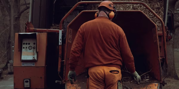 Man die een houthakselaar gebruikt